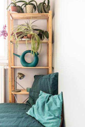 a shelf with potted plants on it next to a bed at Horizon Feng Shui - jardin, terrasse et vue in Ceyrat