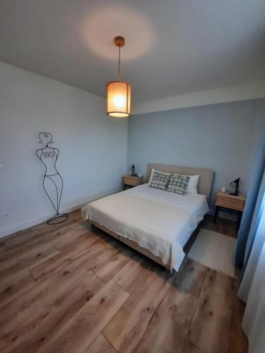 a bedroom with a bed and a painting on the wall at Alfis ApartHotel in Piatra Neamţ