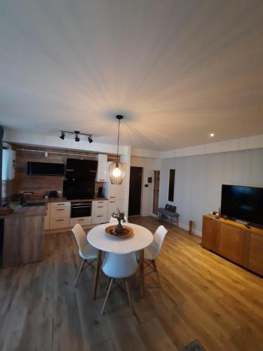 a living room with a table and chairs and a television at Alfis ApartHotel in Piatra Neamţ