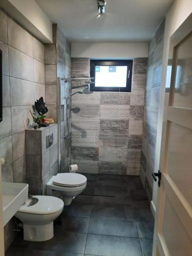 a bathroom with two toilets and a sink at Alfis ApartHotel in Piatra Neamţ