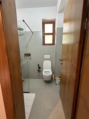 a bathroom with a toilet and a glass shower at Kantina & Ferma Dukat in Vlorë