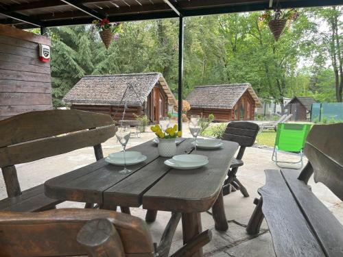 a wooden table and chairs on a patio at Bungalow Bay -2 domki 4 osoby in Łacha