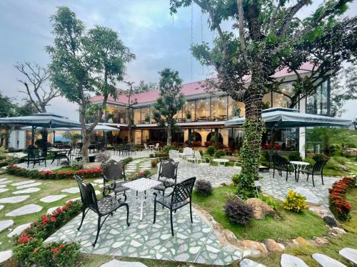 a patio with chairs and tables in front of a building at Sen Plaza Hotel in An Nhiên