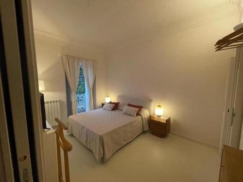 a bedroom with a bed with two lamps and a window at La Dimora di Pindaro in Colledimacine