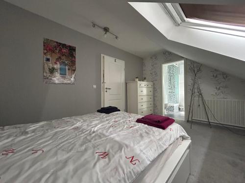 a bedroom with a large white bed with red sheets at Must love dogs in Koblenz