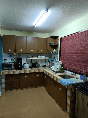 a kitchen with wooden cabinets and a sink at Lin's Homestay in Port Dickson