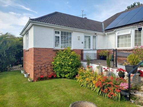 a house with a garden with flowers in the yard at Private apartment, parking, sea and country views in Lyme Regis