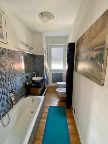 a bathroom with two sinks and a tub and two toilets at Relax fra il mare e le Alpi Apuane a Casa Gabri in Marina di Carrara