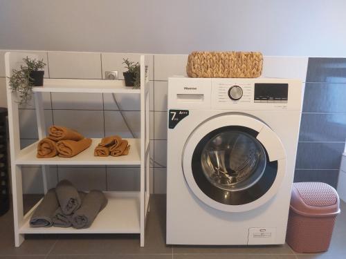 a washing machine in a doll house with two shelves at Apartment Cedar Zagreb Airport - Velika Gorica in Ščitarjevo