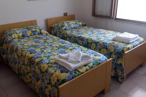 two twin beds in a room withskirts at Stella Marina in Tertenìa