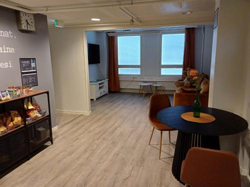 a room with a table and chairs and a living room at Vain Hostels Vääksy in Asikkala