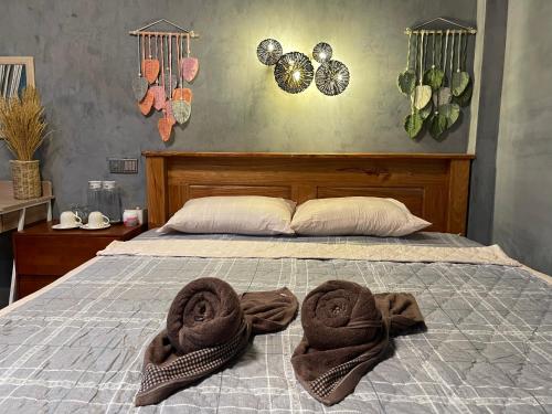 a bed with two towels on top of it at Mother’s House in Battambang