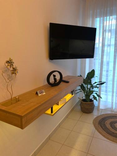 a living room with a flat screen tv on a wall at Seaside Breeze Apartment in Sitia