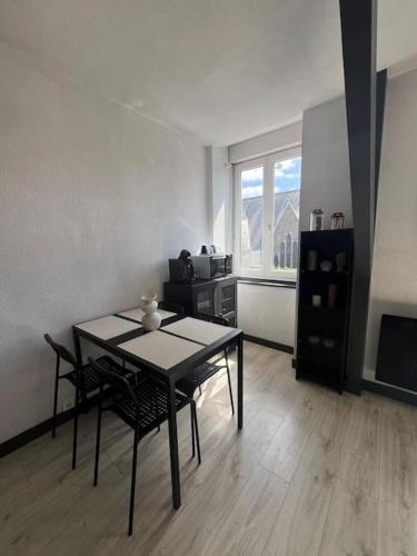 un salon avec une table et des chaises et une cuisine dans l'établissement Square Sainte Thérèse, à Saint-Brieuc