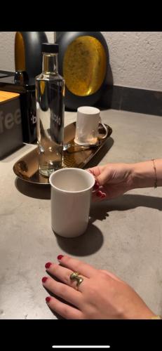 a woman holding a cup on a counter with her hand at Lindiwe Safari Lodge in Hoedspruit