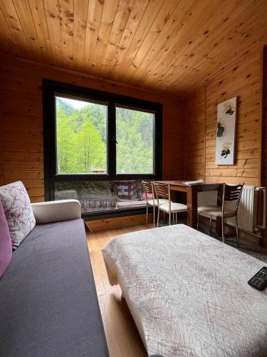 a room with a bed and a table with chairs at Ayder Paradise Otel in Ayder Yaylasi