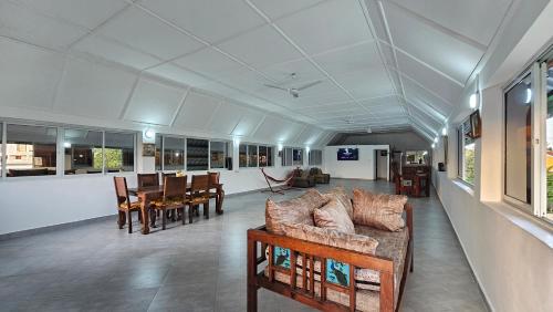 a living room with a couch and tables and chairs at Villa Buerk Serena Suite Bed & Breakfast, Wi-Fi, Pool in Mombasa