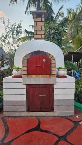 a brick oven with a red door on top of it at Villa Buerk Serena Suite Bed & Breakfast, Wi-Fi, Pool in Mombasa