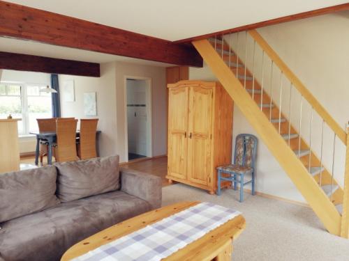 a living room with a couch and a staircase at Seestern in Bünsdorf