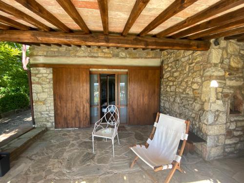 a patio with two chairs and a wooden ceiling at Villa Rosa di Chianti in Radda in Chianti