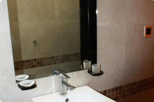 a bathroom with a sink and a mirror at La casa del mochilero in Mexico City