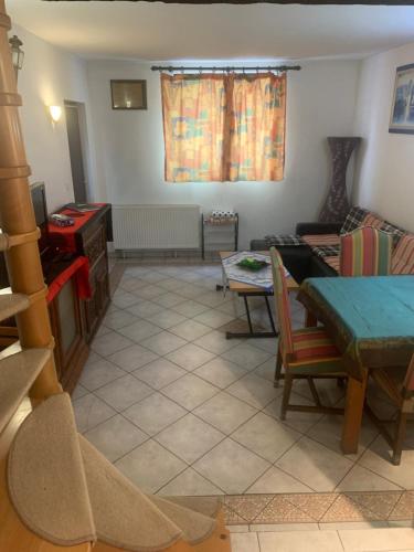 a living room with a table and a couch at Petite maison d Alsace in Brumath