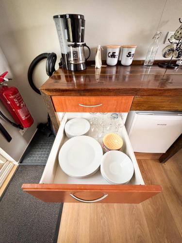 a tray with white plates in a drawer in a kitchen at Áshamrar in Hella