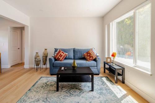 a living room with a blue couch and a table at 1 Palo Alto - Fully Furnished, AC, Private, Parking & Laundry in East Palo Alto