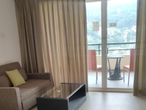 a living room with a couch and a glass table at Thilanka Hotel in Kandy
