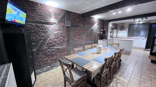 a dining room with a table and a brick wall at Chez Béné in Rochefort