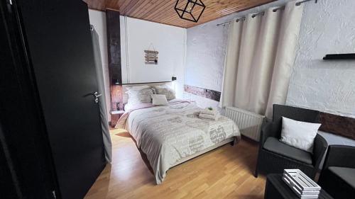 a bedroom with a bed and a chair at Chez Béné in Rochefort