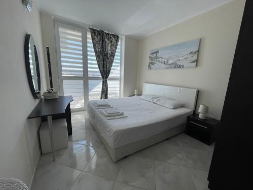 una camera da letto bianca con un letto e una finestra di Apartment with Pool in Atlantis Resort a Burgas