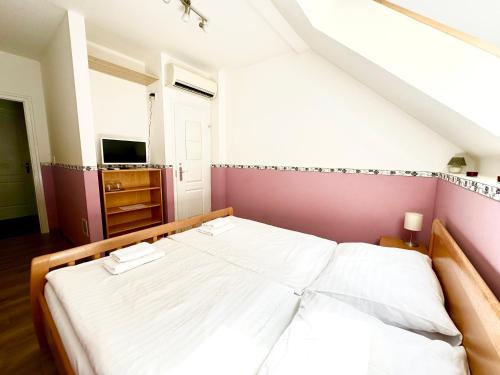 a bedroom with a large bed with white sheets at Privát Adriana in Kremnica