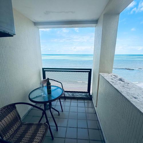 a balcony with a table and chairs and the ocean at Flat 10 andar Hotel Caesar Towers acesso direto praia in Recife