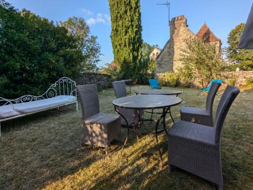 a table and chairs and a bench in a yard at Les Pierres Lotoises - gîte les grandes pierres in Reilhaguet