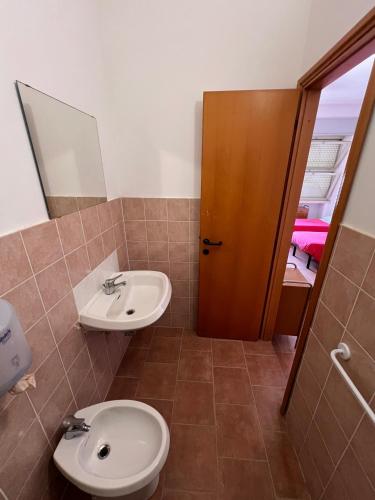 a bathroom with a toilet and a sink at Ostello Paradiso EuroCamp in Cesenatico
