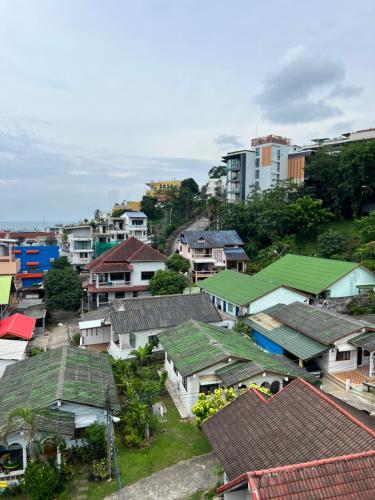 Un grupo de casas con techos verdes en una ciudad. en 07 Antalya Boutique Hotel, en Patong Beach