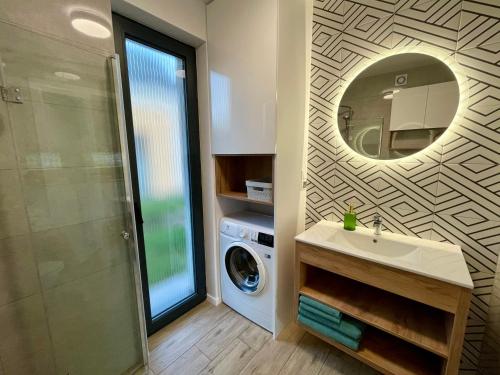 a bathroom with a sink and a washing machine at Domki Na Łące in Święta Katarzyna