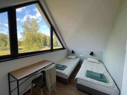 a room with two beds and a window at Domki Na Łące in Święta Katarzyna