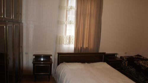a bedroom with a bed and a window with curtains at Guest white house with Terrace in Tskaltubo
