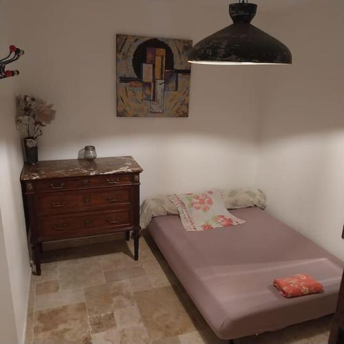 a room with a bed and a dresser and a lamp at LE HAVRE DE PAIX in Peypin