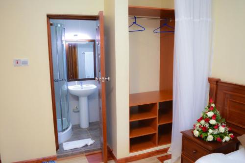 a bathroom with a shower and a toilet and a sink at Red Ruby Hotel in Nairobi
