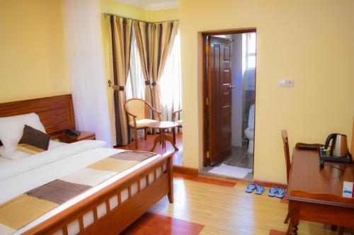 a bedroom with a bed and a bathroom with a toilet at Red Ruby Hotel in Nairobi