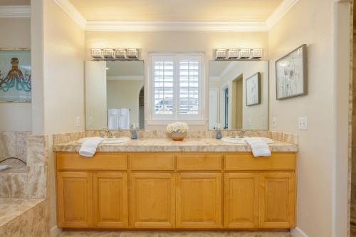 a bathroom with two sinks and a large mirror at Coastal Dream - 2 Blocks to ocean, steps to beach, hot tub, coastal trail, BBQ in Half Moon Bay