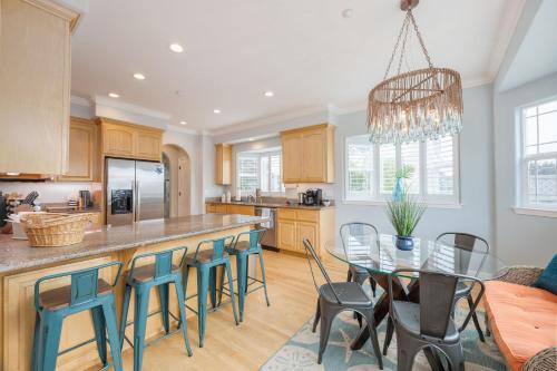 a kitchen with a bar with chairs and a table at Coastal Dream - 2 Blocks to ocean, steps to beach, hot tub, coastal trail, BBQ in Half Moon Bay