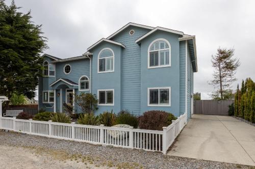 a blue house with a white fence at Coastal Dream - 2 Blocks to ocean, steps to beach, hot tub, coastal trail, BBQ in Half Moon Bay