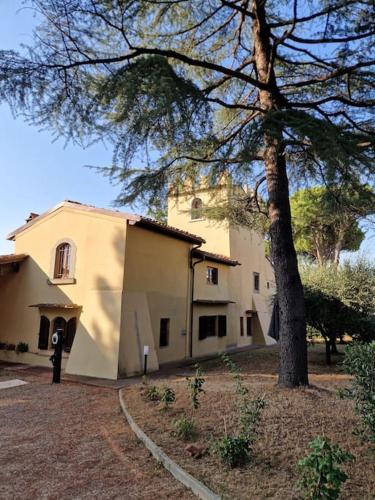 a large white house with a tree in front of it at Villa Castaldi Firenze vicina al centro in Florence