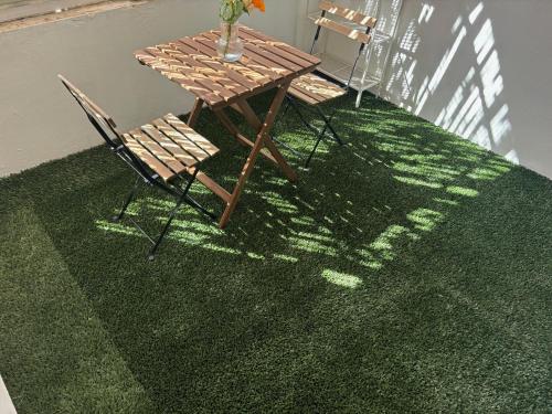 une table et des chaises assises sur un tapis vert dans l'établissement Studio à Marseille avec Terrasse, à Marseille