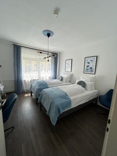 three beds in a room with a window at Mintara Apartment Charme der Stadt Parkplatz Netflix und Sky in Lichtenfels