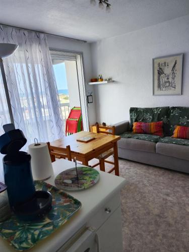 un salon avec un canapé et une table dans l'établissement MontBarcares Le bon coin du Barcarès, au Barcarès